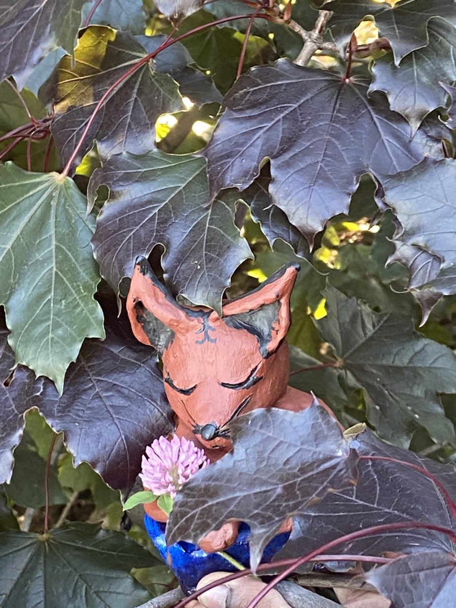 Figurine d’animal inventé, cachée parmi les feuilles d’un arbre